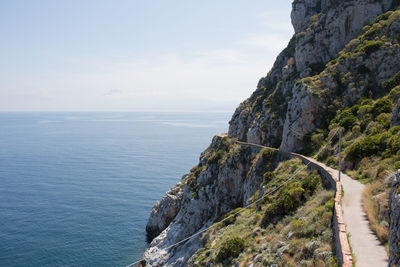 Scenic view of sea by cliff against sky