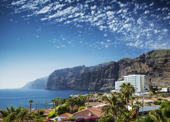 Scenic view of sea by buildings against sky