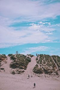 People on beach against sky