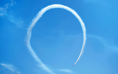 Low angle view of vapor trail against blue sky