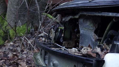 Close-up of abandoned car on field
