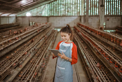 Portrait of young woman standing in greenhouse