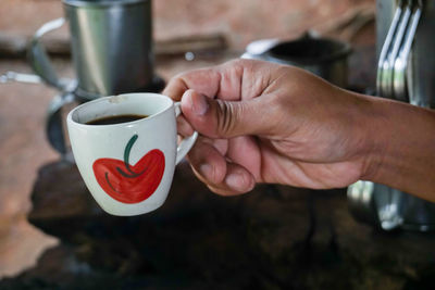 Close-up of hand holding coffee cup