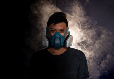 Portrait of young man against black background