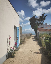 Footpath amidst buildings against sky