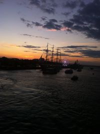 Boats in sea at sunset