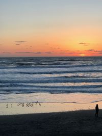 Scenic view of beach against sky during sunset