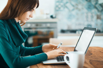 Side view of woman using mobile phone