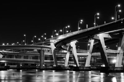 Low angle view of bridge over river at night