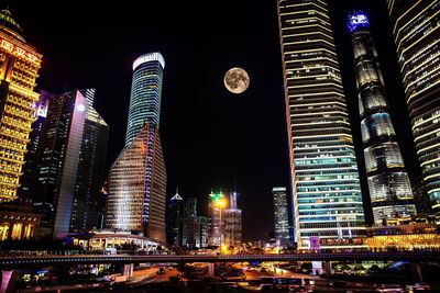 Low angle view of illuminated buildings against sky at night