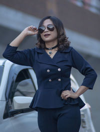 Portrait of young woman standing against wall
