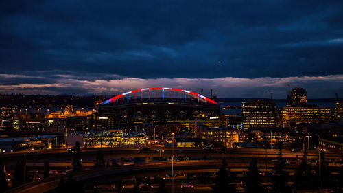 Illuminated bridge over river at night