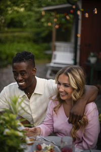 Smiling friends sitting in park