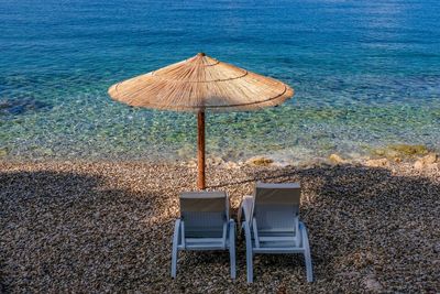 Chairs on beach against sea