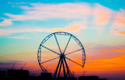 Low angle view of silhouette ferris wheel against sky during sunset