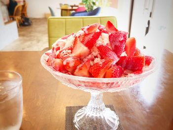 Close-up of chopped fruits in glass bowl on table