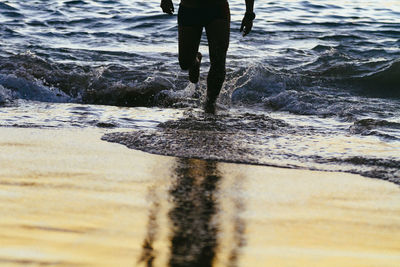 Low section of man wading in sea