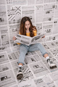 Full length of young woman reading book