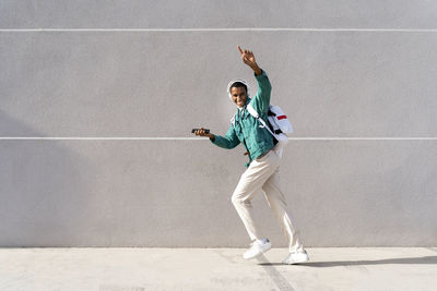 Full length of young man standing against wall