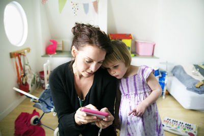 Portrait of happy girl using mobile phone