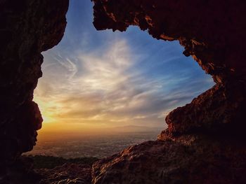 Rock formations by sea against sky during sunset