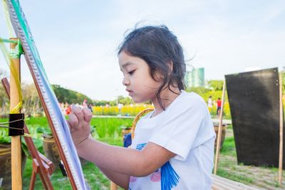 Cute girl painting at park
