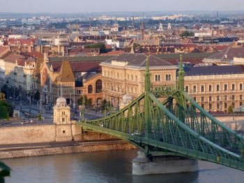 Bridge over river amidst buildings in city