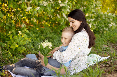 Cute boy with mom on a picnic. son hugs mom