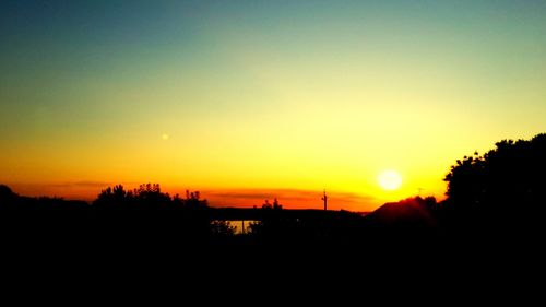 Scenic view of silhouette landscape against orange sky