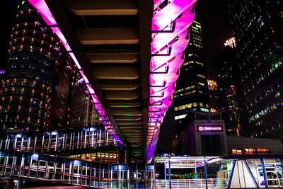 Low angle view of illuminated bridge in city at night