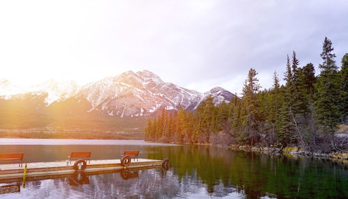 Pier over lake against mountains during winter