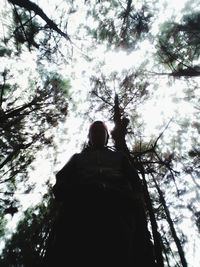 Low angle view of man in forest against sky