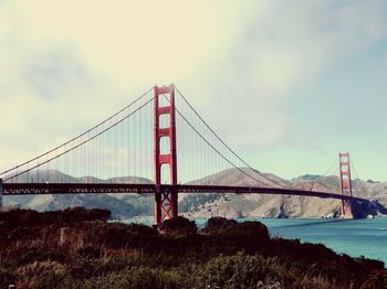 View of suspension bridge against cloudy sky