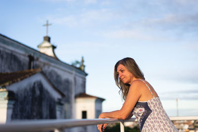 Young woman standing against building