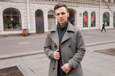 Young man walking down street, autumn or winter cold day. outdoors, outside.