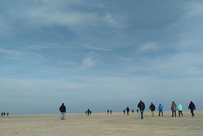 People standing on beach against sky