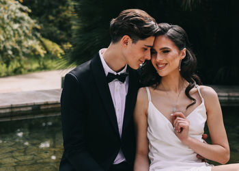 A beautiful couple in love, bride and groom in wedding clothes, walk and pose in the park in nature