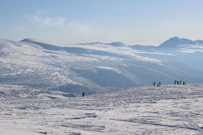 People on snowcapped mountains against sky