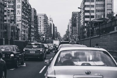 Traffic on city street and buildings against sky