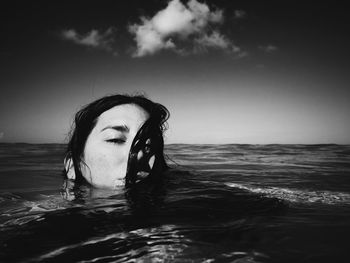 Portrait of woman in sea against sky