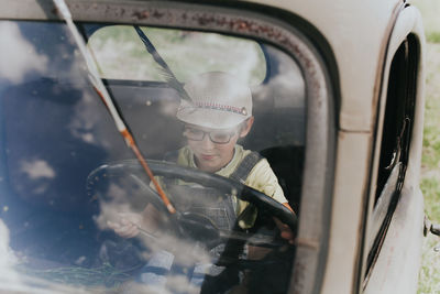 Portrait of man seen through car window