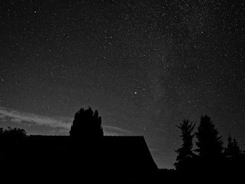 Low angle view of silhouette trees against sky at night