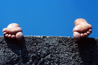 Close-up of man hand against clear blue sky