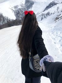 Midsection of woman with snow on mountain