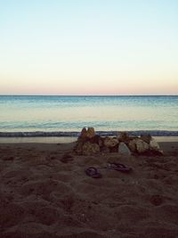 Scenic view of beach against sky at sunset