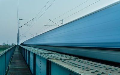 Blurred motion of train on railroad tracks against clear sky