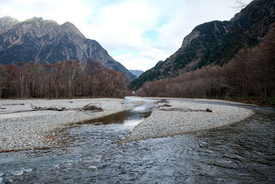 Scenic view of river amidst mountains against sky