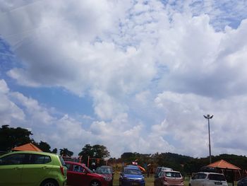 Cars on street in city against sky