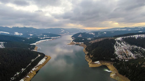 Aerial view of river amidst mountains against sky