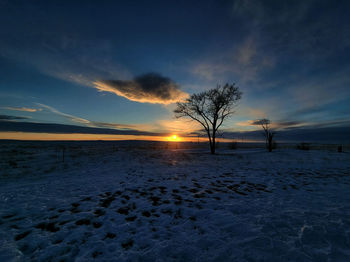 Scenic view of winter against sky during sunset